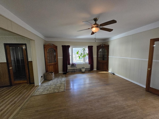 interior space featuring ceiling fan, wood-type flooring, a textured ceiling, and a baseboard heating unit