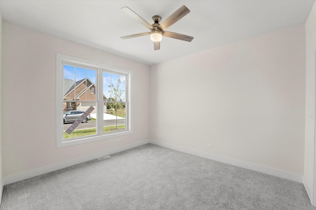 carpeted empty room featuring ceiling fan and plenty of natural light