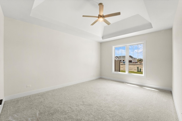 spare room with carpet, ceiling fan, and a raised ceiling