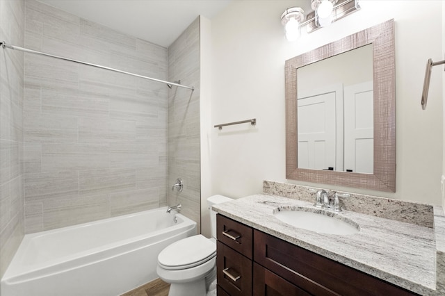 full bathroom with tiled shower / bath, vanity, and toilet