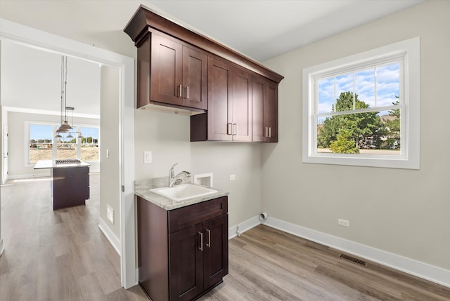 kitchen with light hardwood / wood-style flooring, a healthy amount of sunlight, and sink