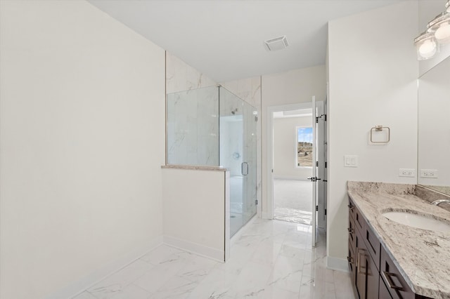 bathroom featuring a shower with door and vanity