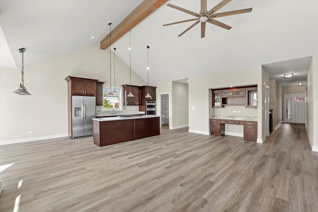 kitchen featuring high vaulted ceiling, pendant lighting, stainless steel appliances, light wood-type flooring, and ceiling fan