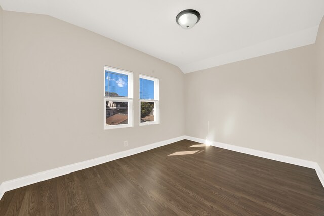 spare room with lofted ceiling and dark hardwood / wood-style flooring