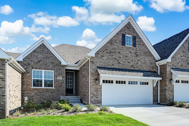 view of front of home featuring brick siding, a shingled roof, and concrete driveway
