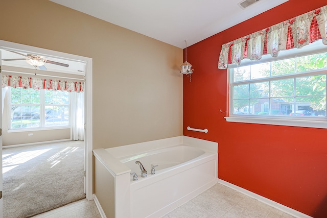 bathroom with a bathtub, ceiling fan, and plenty of natural light