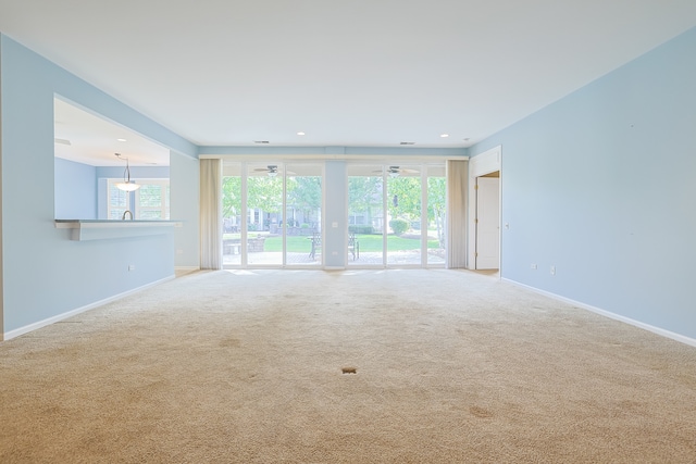 unfurnished room featuring ceiling fan, carpet floors, and a healthy amount of sunlight