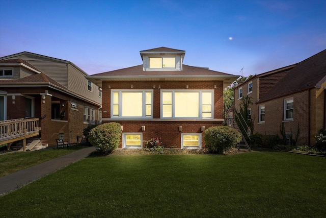 bungalow-style house with brick siding and a front yard
