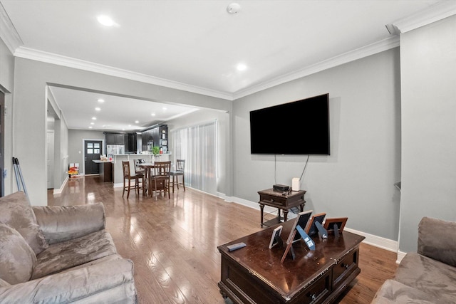 living room with crown molding, wood finished floors, baseboards, and recessed lighting