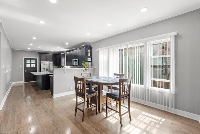 dining space with healthy amount of natural light, light wood-style flooring, recessed lighting, and baseboards
