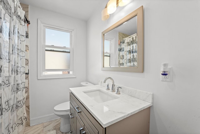 bathroom with curtained shower, vanity, and toilet