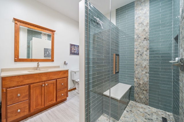 bathroom featuring vanity, hardwood / wood-style floors, an enclosed shower, and toilet