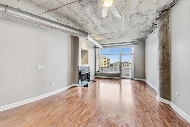 unfurnished living room with wood-type flooring and ceiling fan