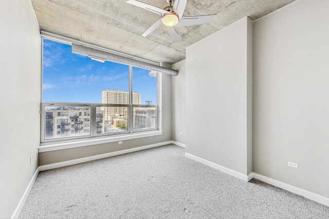 carpeted spare room featuring ceiling fan