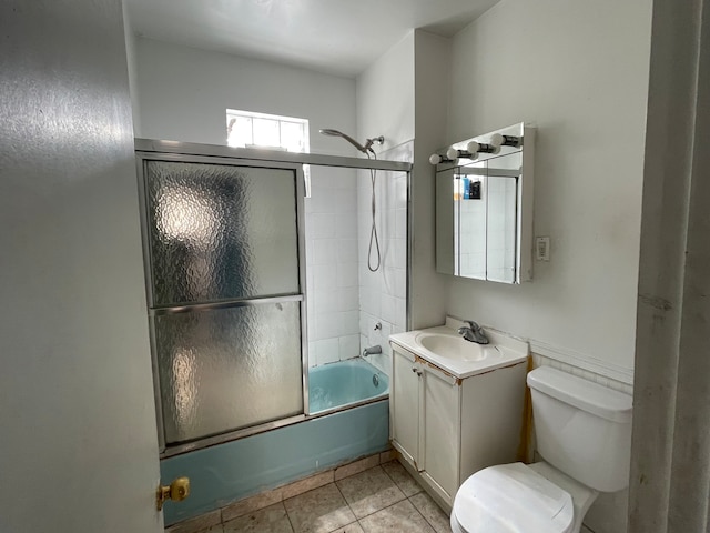 full bathroom with tile patterned flooring, shower / bath combination with glass door, vanity, and toilet