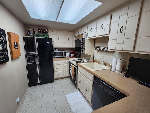 kitchen featuring a sink, light countertops, tasteful backsplash, and black appliances