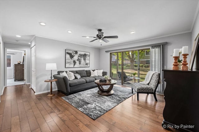 living room with dark wood-type flooring, ceiling fan, and ornamental molding