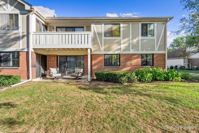 back of house with a yard, a balcony, and a patio