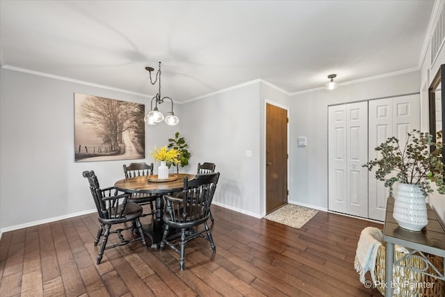 dining space with dark hardwood / wood-style floors, ornamental molding, and an inviting chandelier