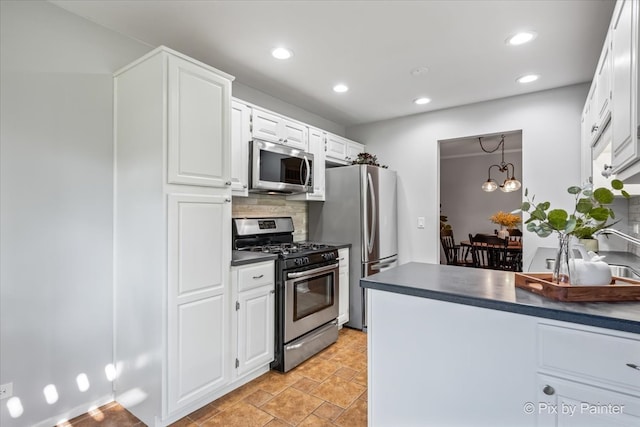 kitchen featuring white cabinets, tasteful backsplash, decorative light fixtures, stainless steel appliances, and a chandelier