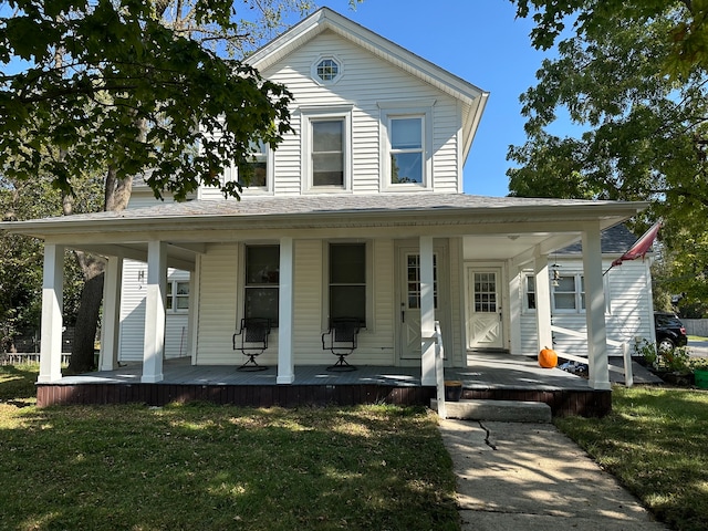 farmhouse inspired home with a front yard and covered porch