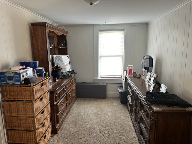 interior space with crown molding, wood walls, and light carpet