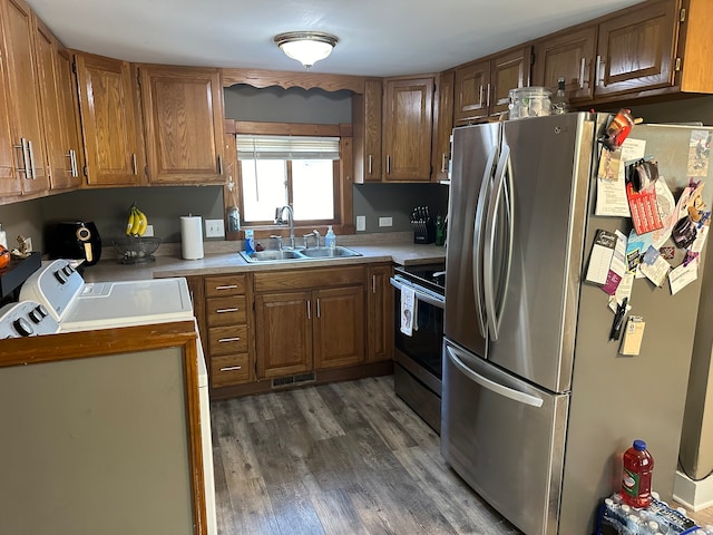 kitchen with sink, stainless steel appliances, dark wood-type flooring, and independent washer and dryer