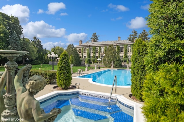 view of pool featuring a patio and an in ground hot tub