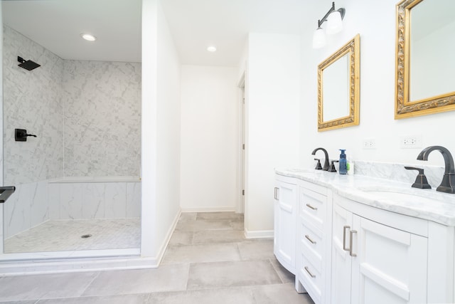 bathroom featuring tiled shower, vanity, and tile patterned flooring