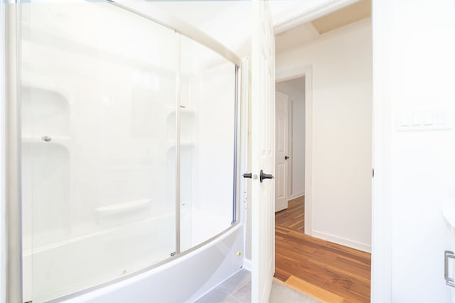 bathroom with wood-type flooring and combined bath / shower with glass door