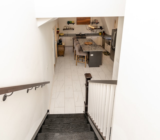 stairway featuring a chandelier and sink