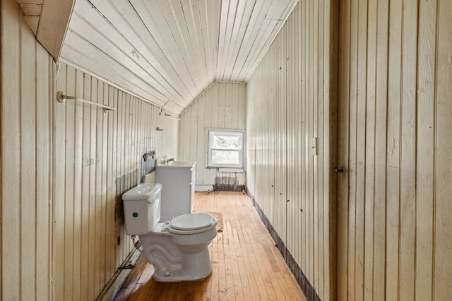 bathroom with wood ceiling, wood-type flooring, vaulted ceiling, wooden walls, and toilet