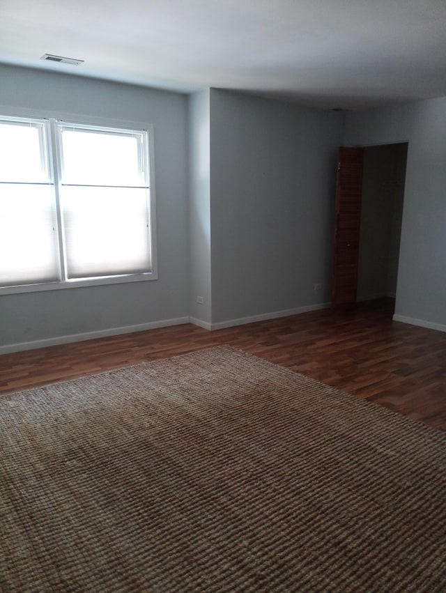 spare room with dark wood-type flooring