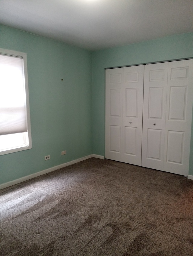 unfurnished bedroom with carpet flooring and a closet