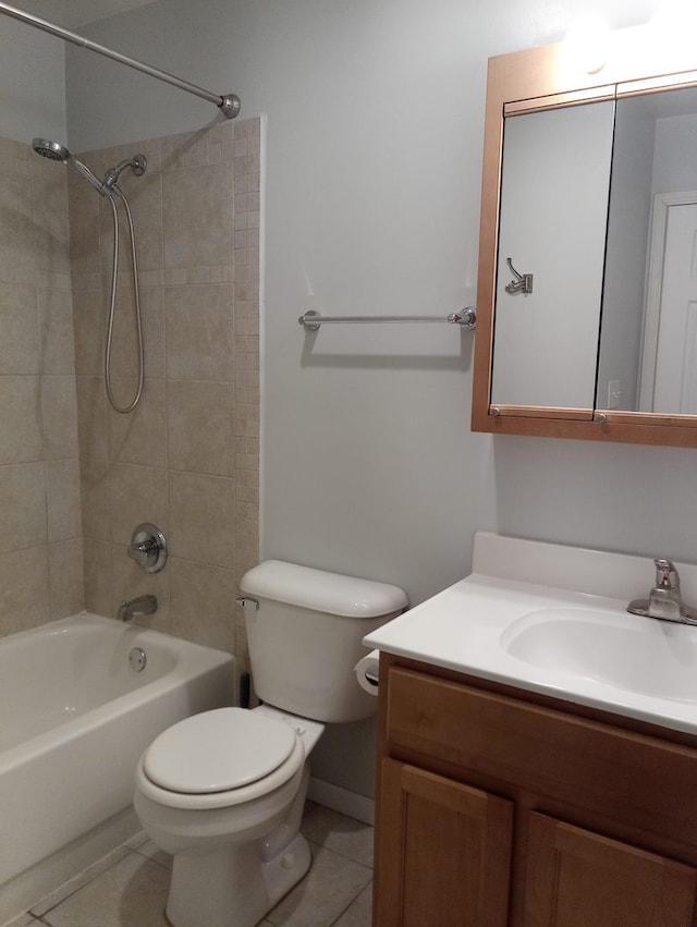 full bathroom featuring tile patterned flooring, tiled shower / bath, vanity, and toilet