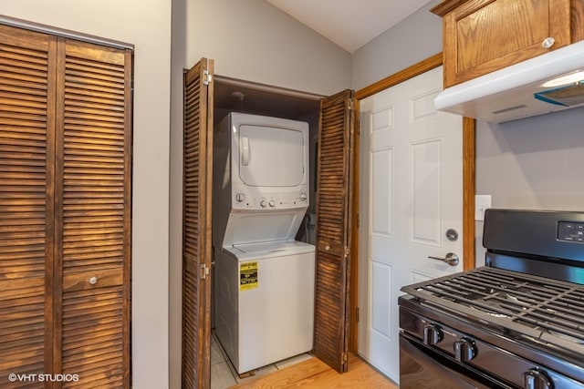 clothes washing area with light wood-type flooring and stacked washer and clothes dryer