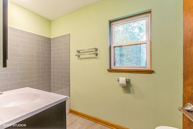 bathroom with hardwood / wood-style floors, vanity, and toilet