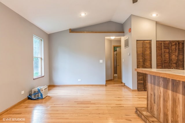 empty room with lofted ceiling and light hardwood / wood-style floors