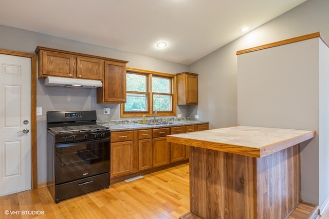 kitchen featuring light hardwood / wood-style floors, lofted ceiling, sink, and gas stove