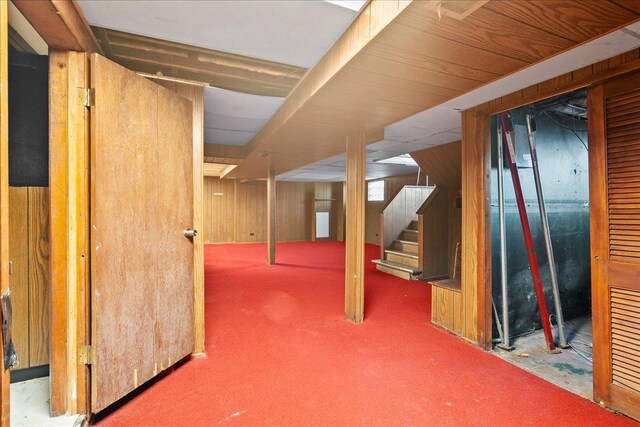 basement with carpet flooring and wood walls