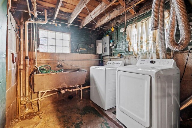 clothes washing area with sink, electric panel, and washing machine and dryer