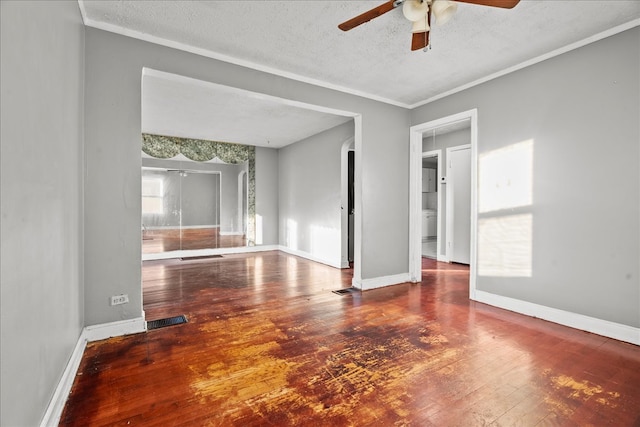 empty room featuring a textured ceiling, wood-type flooring, ornamental molding, and ceiling fan