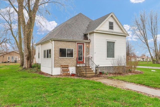 view of front of property featuring a front yard and roof with shingles