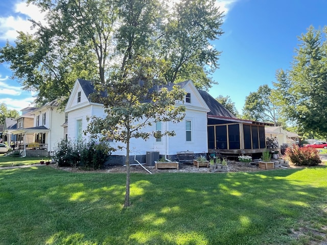 back of property featuring a lawn, cooling unit, and a sunroom