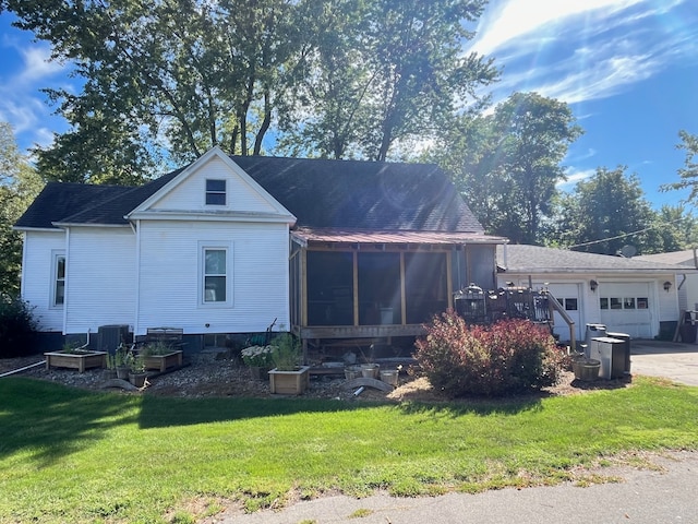 view of front of property with a garage, a sunroom, and a front yard