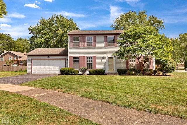 colonial home featuring a front yard and a garage