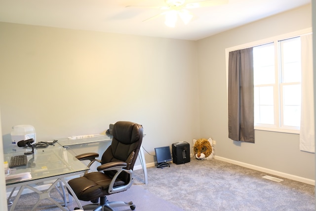 carpeted office space featuring ceiling fan