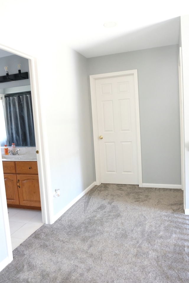 unfurnished bedroom featuring light carpet and sink