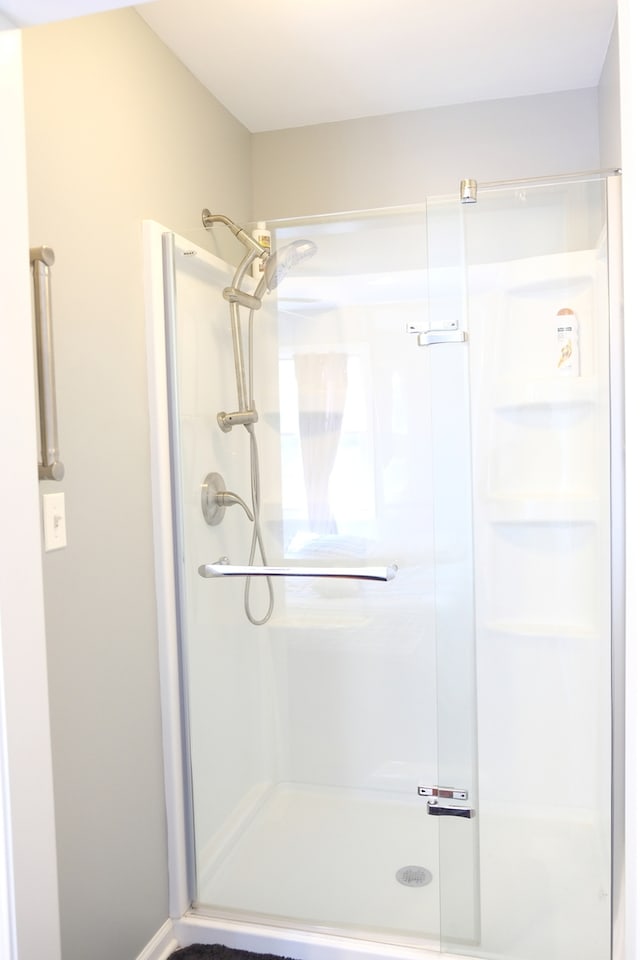 bathroom featuring a shower with door