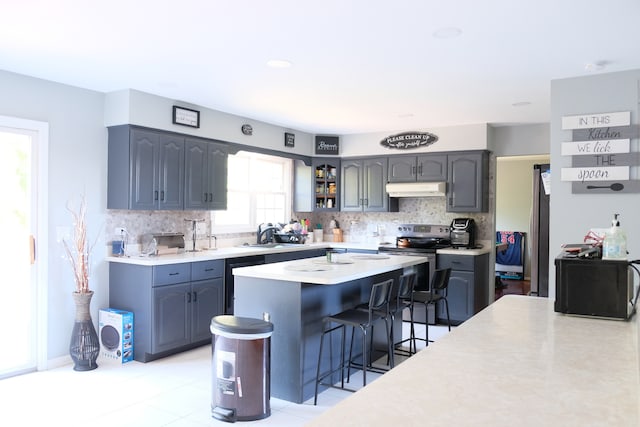 kitchen featuring a breakfast bar area, decorative backsplash, electric range, and a kitchen island